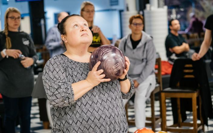 Jaana Siltala pitää kädessään keilapalloa ja keskittyy heittoon.