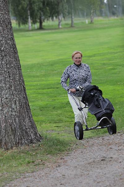 Maija Puranen työntää golfkärryä