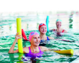 Keski-ikäisiä naisia uima-altaassa vesijumpassa.