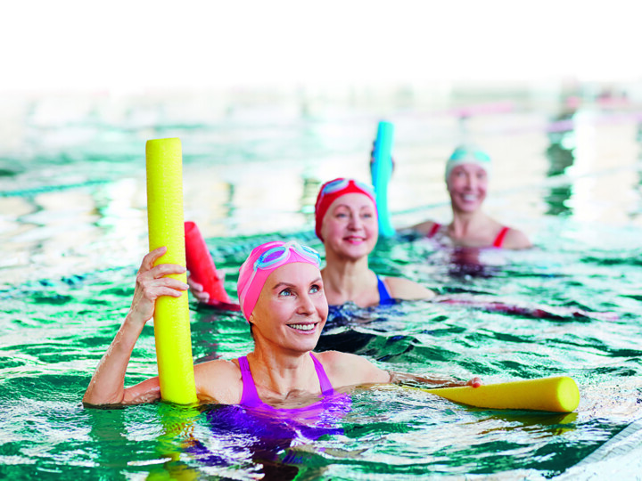Keski-ikäisiä naisia uima-altaassa vesijumpassa.
