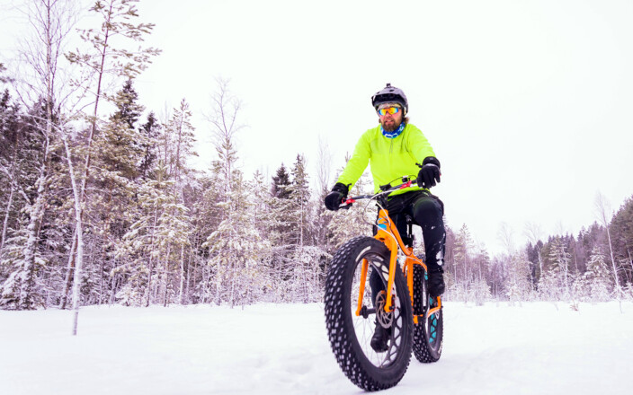 Esa Kynäslahti polkee läskipyörällä lumisella metsätiellä