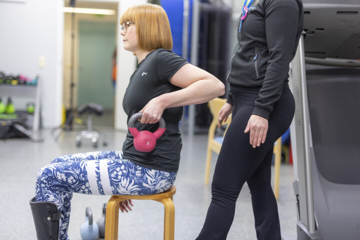 Milla Levikari treenaa kahvakuulalla fysioterapeutin ohjauksessa.
