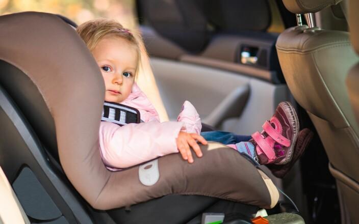 Taaperoikäinen lapsi istuu turvaistuimessa auton takapenkillä.