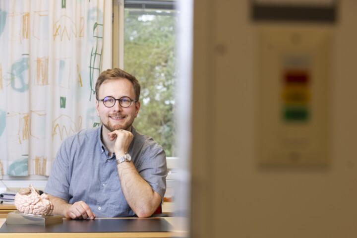 Neuropsykologi Alar Kaskikallio istuu työpöytänsä ääressä Maskun neurologisessa kuntoutuskeskuksessa.
